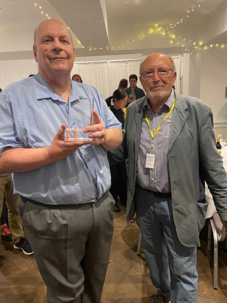 John Bryant, left, holding the Howard Milton Award for Cricket Scholarship, presented by Nigel Hancock (right)